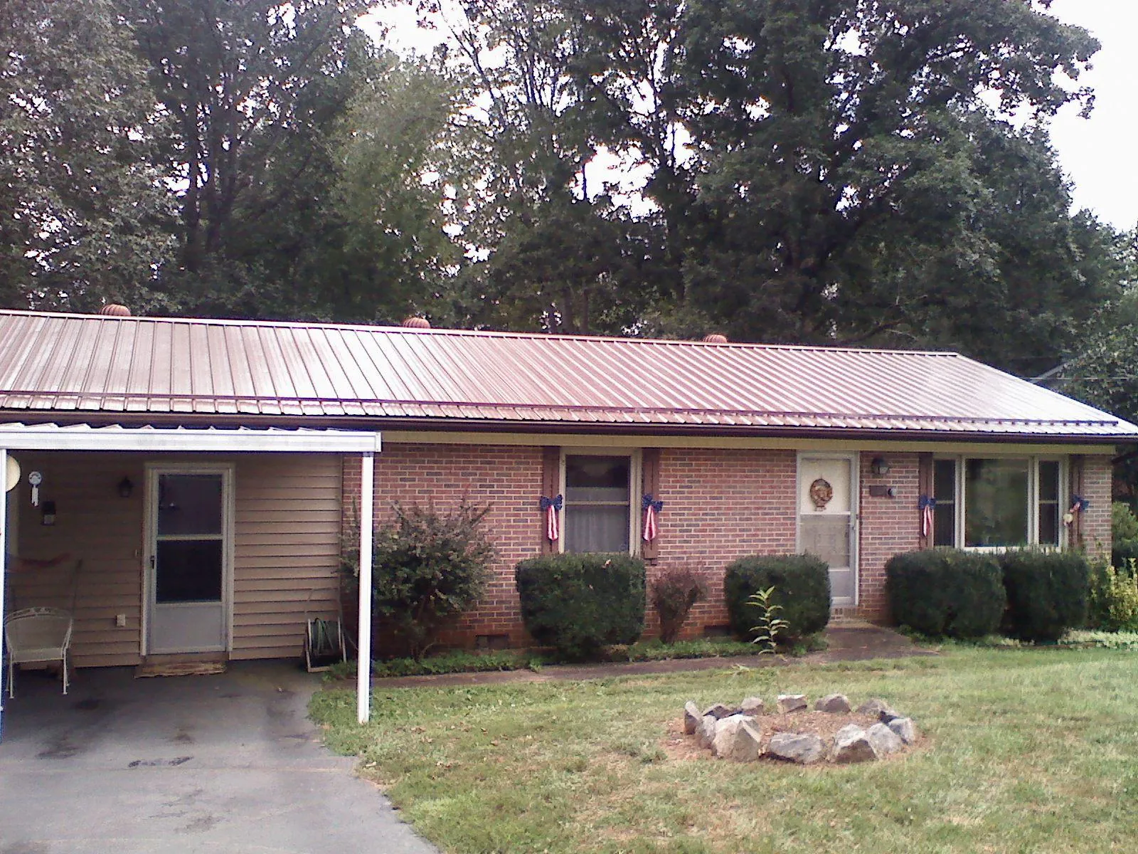 Bronze metal roof and carport on a brick ranch home — Roof Repair work by our crew in Alleman